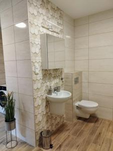 a bathroom with a sink and a toilet at Apartament Marzenie 4 - Opole in Opole