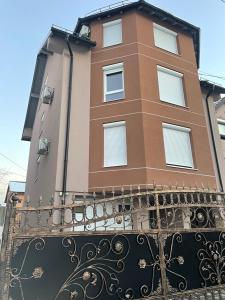 um edifício alto com uma cerca em frente em Apartment Balicevac2 Ilidza em Saraievo