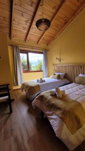 a bedroom with three beds in a room at Ruca Nel in El Calafate