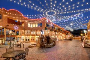 a building with christmas lights and tables and chairs at Ski In Out Luxury Penthouse #1706 With Hot Tub & Great Views - 500 Dollars Of FREE Activities And Equipment Rentals Daily in Winter Park