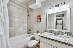 a bathroom with a white tub and a sink and a toilet at Global Cup Dallas Boutique Flat - Arboretum Tickets Included in Dallas +20 photos