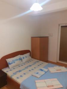 1 dormitorio con 1 cama con sábanas azules y armario en Apartmani BAKULE en Peštani