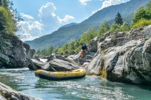 a man standing next to a raft in a river at [FREE WIFI] Elegante bilocale vicino alle piste in Scopello