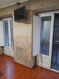 um quarto com duas portas e uma televisão na parede em La Guinda Real em Vigo