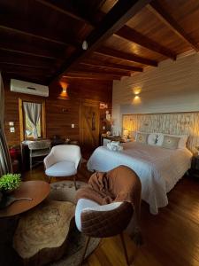 a bedroom with a large bed and a living room at IL Rifugio Cabanas in Urubici