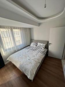 ein Schlafzimmer mit einem Bett in einem Zimmer mit zwei Fenstern in der Unterkunft Zeytinburnu merkezi konumda, sıfır daire & eşyalar in Istanbul