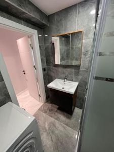 ein Bad mit einem Waschbecken und einem Spiegel in der Unterkunft Zeytinburnu merkezi konumda, sıfır daire & eşyalar in Istanbul