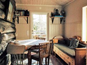 een eetkamer met een tafel en stoelen en een open haard bij Holiday home MORA II in Börka