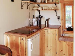 een kleine keuken met een wastafel en een aanrecht bij Holiday home MORA in Börka