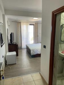 ein Schlafzimmer mit einem Bett und einem TV in einem Zimmer in der Unterkunft Hotel Tirona in Tushemisht