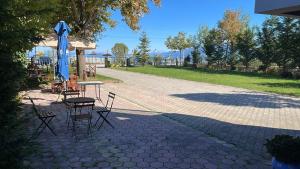 a patio with a table and chairs and an umbrella at Hotel Tirona in Tushemisht