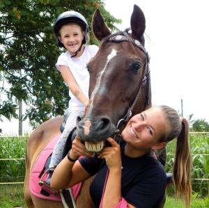 una mujer sosteniendo a una niña en un caballo en Csatangoló Lovas Vendégház, 