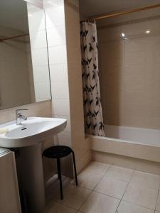 ein Badezimmer mit einem Waschbecken und einer Badewanne mit einem Duschvorhang in der Unterkunft Andramari Tourist Home Parking& wifi in Amorebieta-Etxano