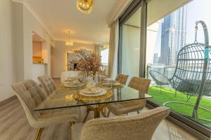 a dining room with a glass table and chairs at WORLD CLASS 3BR with full BURJ KHALIFA and FOUNTAIN VIEW in Dubai