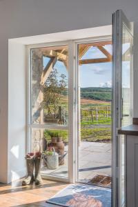 an open door to a patio with a view at Dairy Cottage in Gatehouse of Fleet