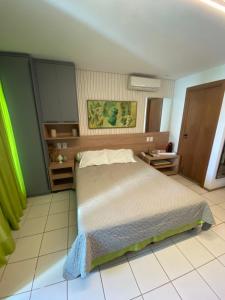 um quarto com uma cama e piso em azulejo em Studio Muro Alto em Porto de Galinhas