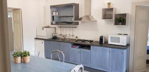 una cucina con armadi blu e forno a microonde di La Dimora del Sole a Finale Ligure