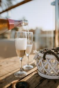 Bungalows El Palmital - Adults Only في بلايا ديل إنغلز: يتم صب زجاجة من الشمبانيا في كأسين من النبيذ