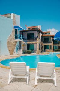dos sillas blancas sentadas junto a una piscina en Hotel Arrecife dos Corais en Cabo de Santo Agostinho