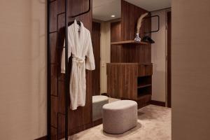 un bagno con accappatoio appeso a una parete in legno di Van der Valk Hotel Delft A4 a Den Hoorn