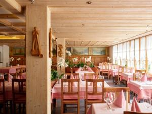 ein Restaurant mit rosa Tischen und Stühlen in einem Zimmer in der Unterkunft Hotel Steinbock in Brienz