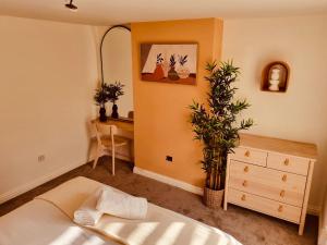 a bedroom with a bed and a desk with a plant at 'Afton' at stayBOOM in Lancaster