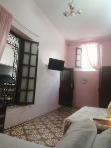 um quarto com uma cama, uma janela e uma porta em Bab aissi home em Meknès