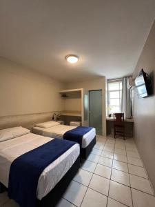 una camera d'albergo con due letti e una televisione di Europa Hotel Brasília a Taguatinga