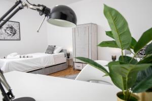 a room with two beds and a lamp and a plant at Apartman Tihana in Vinkovci