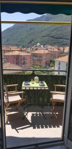 a patio with a table and benches and a view of a city at La Dimora del Sole in Finale Ligure