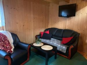 a living room with a black leather couch and a table at Jasmin in Stegna