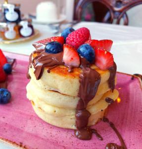 un postre con fresas y arándanos en un plato rosa en Barony House, en Edimburgo