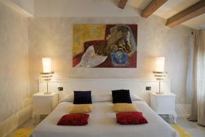 a bedroom with a large white bed with two lamps at Art Hotel Al Fagiano in Padova