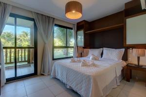 a bedroom with a bed and a large window at VG Sun #102 - Apto de Dois Quartos por Carpediem in Paracumbuca
