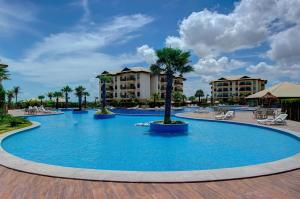 a pool at a resort with palm trees and buildings at VG Sun #102 - Apto de Dois Quartos por Carpediem in Paracumbuca +37 photos