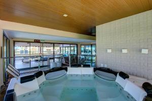 a swimming pool in a gym with chairs in a building at VG Sun #102 - Apto de Dois Quartos por Carpediem in Paracumbuca