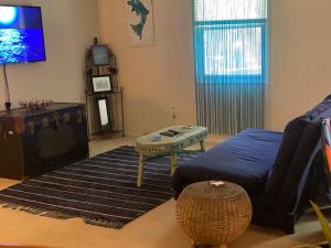 a living room with a couch and a table and a tv at Reef Dreamer Artist’s Retreat in Gulf Breeze