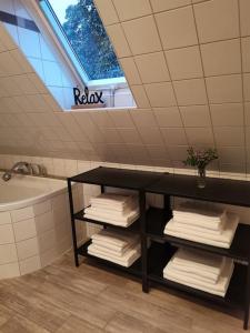 a bathroom with a sink and a shelf with towels at Fewo "Am Bienenstock" in Dallgow-Döberitz in Dallgow