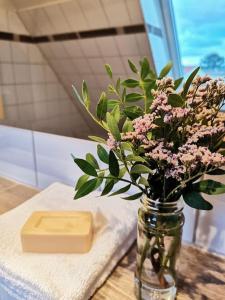 un vase avec des fleurs et une barre de savon sur une table dans l'établissement Fewo "Am Bienenstock" in Dallgow-Döberitz, à Dallgow