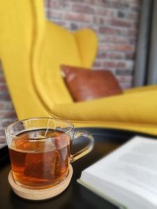 a cup of tea sitting on a table next to a book at Fewo "Am Bienenstock" in Dallgow-Döberitz in Dallgow