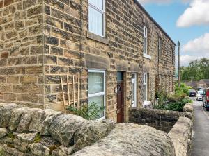 a brick building with a stone wall in front of it at Ivy Cottage in Two Dales