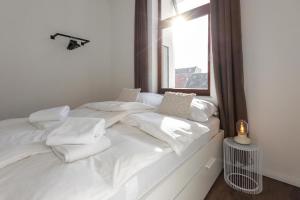 Cama blanca con sábanas blancas y ventana en Koje Eins I Großes Apartment mit 2 Schlafzimmern, en Bremerhaven