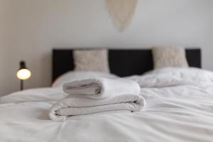 a pile of towels sitting on top of a bed at Koje Eins I Großes Apartment mit 2 Schlafzimmern in Bremerhaven +19 photos