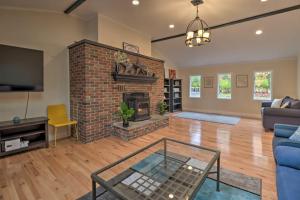 a living room with a brick fireplace and a blue couch at Pocono Home with Hot Tub, Fireplace and Game Room! in Saylorsburg