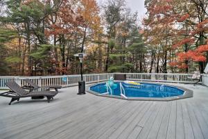 a woman is standing on a deck next to a swimming pool at Pocono Home with Hot Tub, Fireplace and Game Room! in Saylorsburg