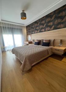 a bedroom with a large bed with blue pillows at Appartement Morillon 47 ou 39 au quartier Maarif in Casablanca