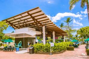 einem Pavillon in einem Resort mit Tischen und Stühlen in der Unterkunft Hotel Punta Leona in Jacó