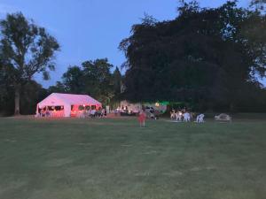 a group of people in a field with a pink tent at Unique Orchard Lodge for couples with hot tub in Strathaven +52 photos