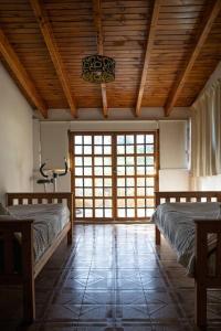 a bedroom with two beds and a wooden ceiling at Casona alegre con pileta y amplio jardin in Las Compuertas