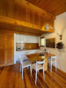 une cuisine avec une table et des chaises en bois dans l'établissement Accogliente chalet in mansarda, à Courmayeur